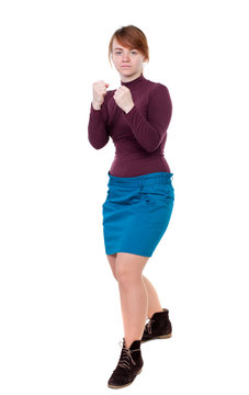 skinny woman funny fights waving his arms and legs. Isolated over white background. Girl with red hair standing in a boxing pose and looks in the frame.