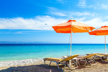 deck chairs and umbrella on background of sea  pebbles