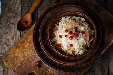 Sauerkraut with berries in clay bowl. Top wiev. Autumn concept
