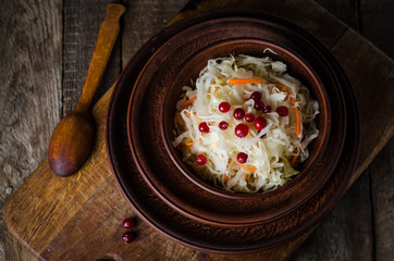 Sauerkraut with berries in clay bowl. Top wiev. Autumn concept