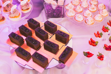 Candy bar, decorated table with sweets and flowers, baked goods