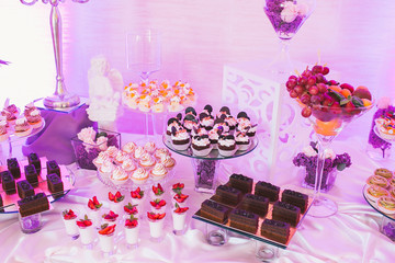 Candy bar, decorated table with sweets and flowers, baked goods