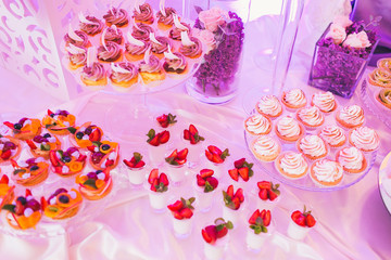 Candy bar, decorated table with sweets and flowers, baked goods