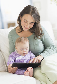 Caucasian mother reading to baby with Down Syndrome
