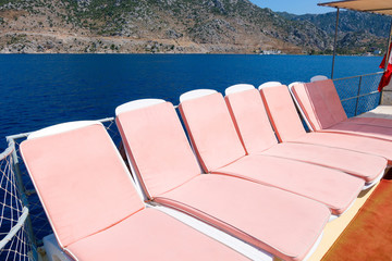 Pink sun beds on a boat in the sea