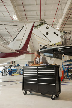 Caucasian man working in airplane hangar
