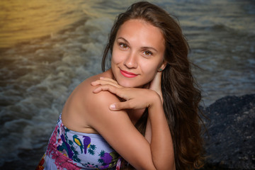 Beautiful young girl smiling, posing on the beach in the evening