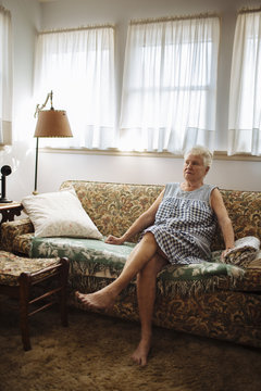 Older woman sitting on sofa in living room