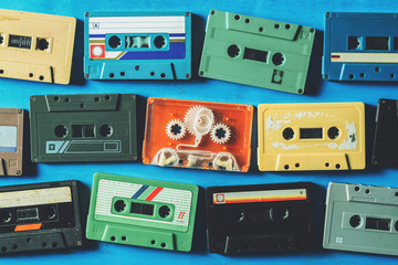 Old cassette tapes on blue wooden table, top view
