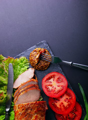 Baked pork fillet, rings of tomato leaf of salad, french mustard