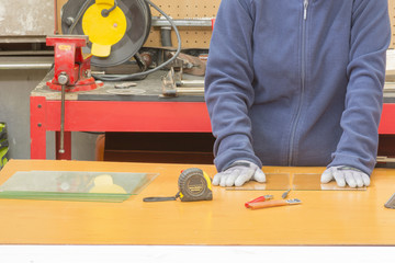 trabajador cortando cristales con el cortador de vidrios manual