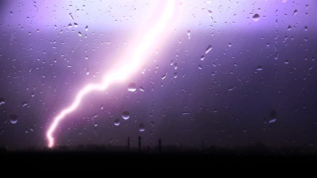 Strong Thunderstorm With The Rain Over A City Through Window Glass.