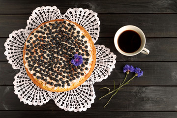 Homemade blueberry pie with a cup of coffee and the cornflowers