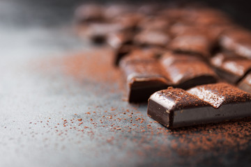 Dark chocolate on a dark background, closeup with place for text, selective focus