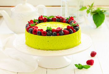 Home pistachio cheesecake with raspberries and blueberries.