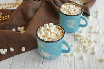 Mugs of hot cocoa drink with marshmallows on table