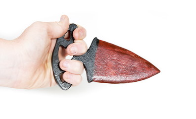 Childrens hand holds wooden model of a knife