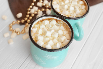 Mugs of hot cocoa drink with marshmallows on table