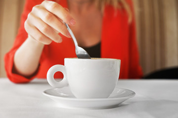 Woman with cup of coffee sitting in cafe