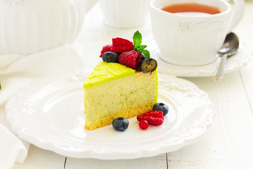Home pistachio cheesecake with raspberries and blueberries.