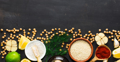 Ingredients for hummus on a black wooden background