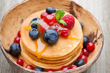 Stack of pancakes with blueberry and fresh berry.
