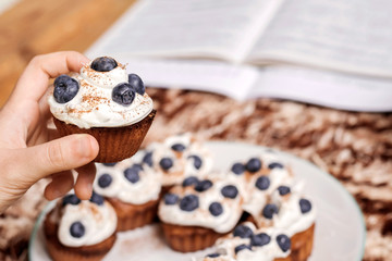 Hand holding blueberry muffin.