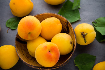 Apricots with leaves on the old wooden table.