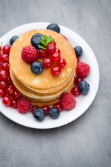 Stack of pancakes with blueberry and fresh berry.