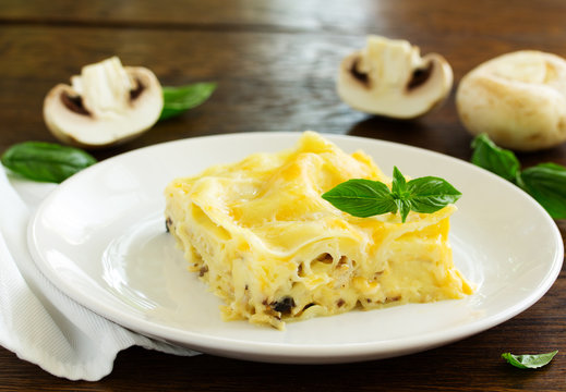 A piece of lasagna with chicken and mushrooms.