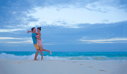 couple in bright clothes having fun at tropical beach