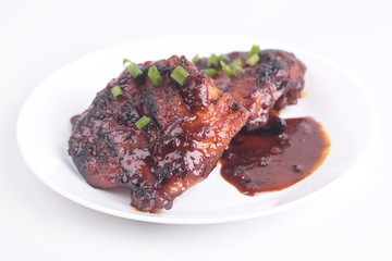 Grilled chicken or ayam golek on white plate, white background.