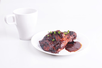 Grilled chicken or ayam golek on white plate, white background.