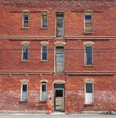old aged brick building with windows and door
