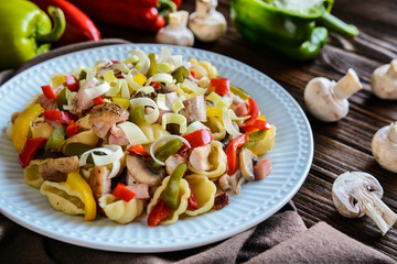 Pasta salad with backed chicken breast, fried bacon, pepper, mushrooms and leek
