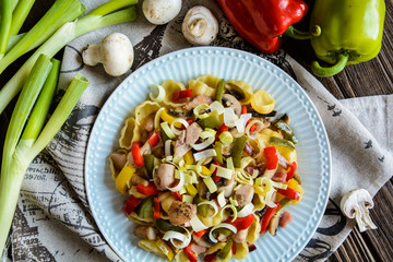 Pasta salad with backed chicken breast, fried bacon, pepper, mushrooms and leek