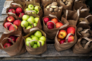 paper bags with organic apples and potatoes on the market,