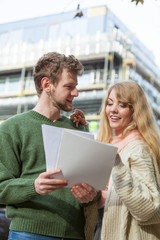 Couple with blueprint project keys on construction site