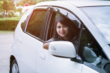 a beautiful young woman driving cars white
