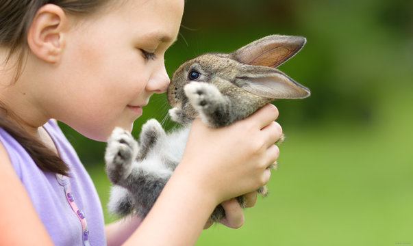 Girl is holding a little rabbit