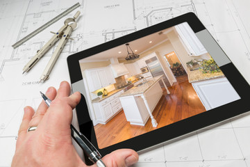 Hand of Architect on Computer Tablet Showing Custom Kitchen Photo Over House Plans, Compass and...