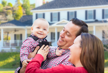 Fototapeta premium Adorable Little Baby Boy Having Fun With Mother and Father In Front Yard Of House.