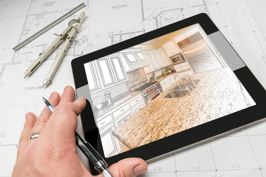 Hand of Architect on Computer Tablet Showing Custom Kitchen Illustration Photo Combination Over House Plans, Compass and Ruler.