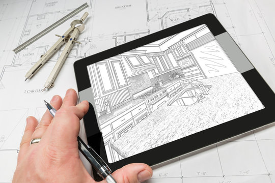 Hand of Architect on Computer Tablet Showing Custom Kitchen Illustration Photo Combination Over House Plans, Compass and Ruler.