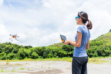 Woman controlling the flying drone