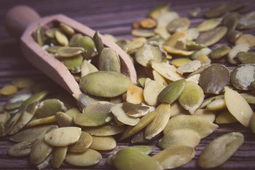Vintage photo, Pumpkin seeds with spoon on wooden background