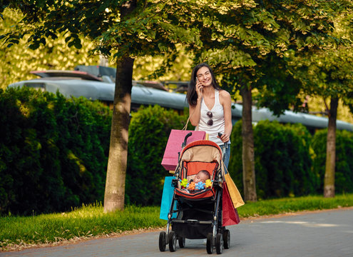 shopping Woman With Baby Carriage Using Cell Phone