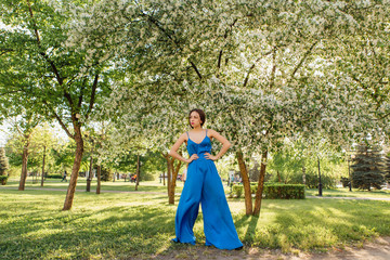 Fototapeta premium Beautiful young woman standing near the apple tree.