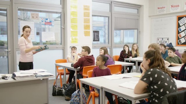 4K Teacher teaching pupils in school class
