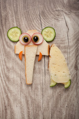 Amusing elephant made of cheese and bread on wooden background